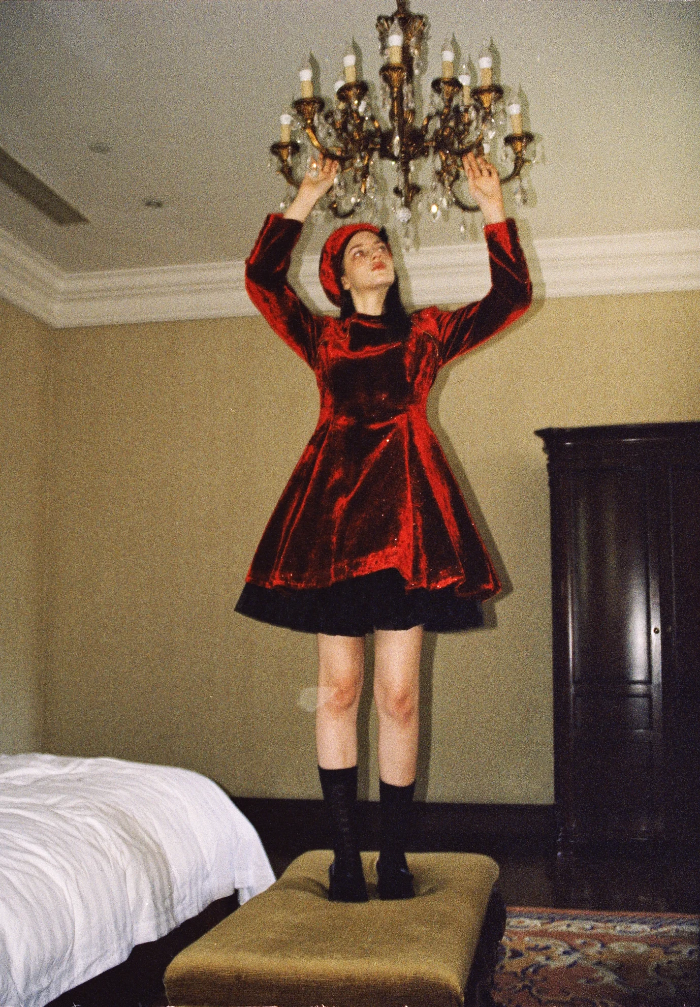 Lookslulu red velvet dress beneath a chandelier